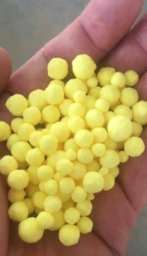 Handful of uniform granular sulphur pellets